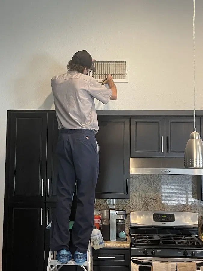 Technician inspecting an air vent during HVAC service in Lake Goodwin